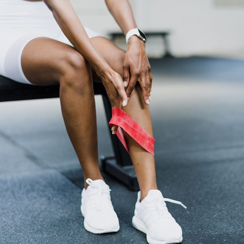 Mujer deportista con banda roja en la pierna